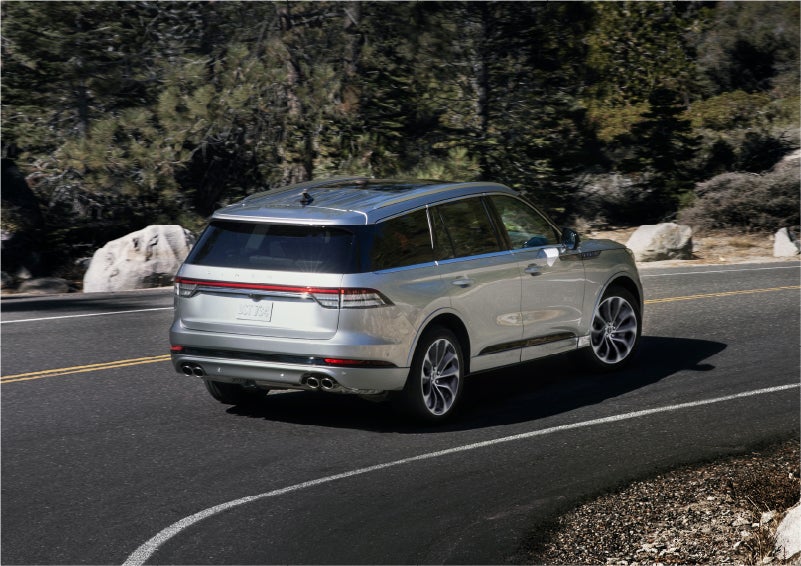A 2023 Lincoln Aviator® Grand Touring model is shown being driven on a tight turn of a mountain road | Central Florida Lincoln in Orlando FL